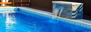 a swimming pool with a fountain in the middle at Hotel Rideamus in Villa Gesell