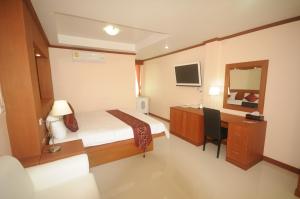 een kleine kamer met een bed, een bureau en een spiegel bij Chinathip Yusabuy in Nan