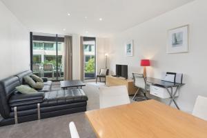 uma sala de estar com um sofá e uma mesa em Edgewater 108 em Geelong
