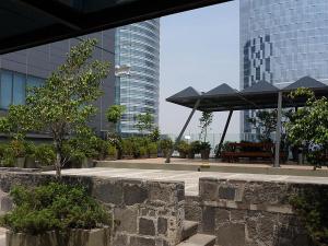 a pavilion with a table and umbrella in front of buildings at Capri Reforma 410 in Mexico City