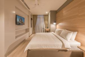 a hotel room with a bed and a desk at Jinhold Hotel & Serviced Apartment in Miri