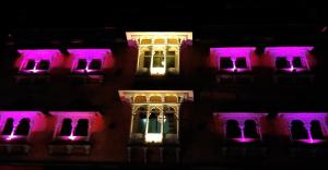 a building lit up in purple and white at night at Hotel Parvati Palace Sehore in Sehore