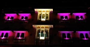 a building lit up in purple and white at night w obiekcie Hotel Parvati Palace Sehore w mieście Sehore