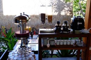 einen Tisch mit einem Mixer sowie einige Tassen und Teller in der Unterkunft Paradesa Villa in Gili Trawangan
