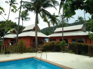 a house with a swimming pool next to a resort at Lanta Cottage - SHA Plus in Ko Lanta
