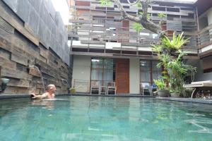 a baby in a swimming pool in a building at Semarandana Bedrooms and Pool in Sanur
