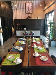 een lange houten tafel met borden en borden erop bij THE TREE Sleep and Space in Trang