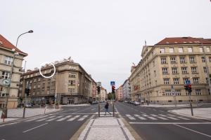 uma pessoa de pé numa faixa de pedestres no meio de uma rua da cidade em Apartmán Bubeneč em Praga