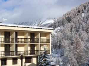 a hotel with a snow covered mountain in the background at Les Carlines in Vars