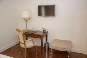 escritorio con lámpara y 2 sillas en una habitación en Hotel Villa Michelangelo, en Citta' Sant'Angelo