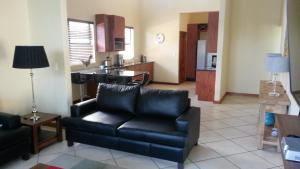 a living room with a couch and a kitchen at 398 Vaal de Grace Golf Estate in Parys