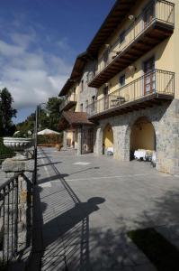 a large building with a balcony and a patio at Hotel Camoretti in Almenno San Bartolomeo