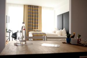 a living room with a bedroom with a bed and a table at Stein Boardinghouse in Koblenz