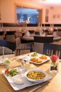 una mesa con dos platos de comida. en Landidyll Hotel Haus Hochstein, en Wenholthausen