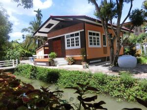 a house with a tree in front of it at Meephawa Resort in Amphawa