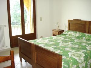 a bedroom with a bed with a green and white comforter at Agriturismo La Cinciallegra in Riva presso Chieri