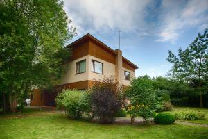 a house with a yard with bushes and trees at Riga Airport Jurmala apartments in Rīga