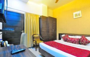 a bedroom with a bed and a table and a television at Hotel Central Park 17 in Chandīgarh