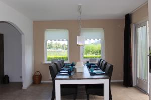 a dining room with a table and chairs at Oostvaarders vakantiehuis in Almere