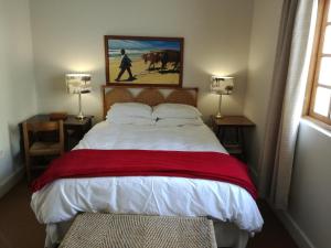 a bedroom with a large bed with a red blanket at Valley Guest House in Port Elizabeth