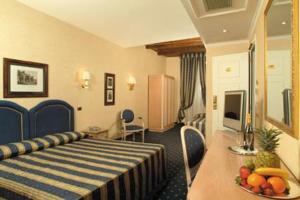 a hotel room with a bed and a table with a bowl of fruit at Hotel Valle in Rome