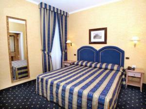 una camera d'albergo con un letto blu e uno specchio di Hotel Valle a Roma