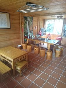 Zimmer mit Holztischen und Bänken in einem Zimmer in der Unterkunft Xin Cai Homestay in Meishan