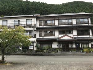 田边市龙津温泉丸井旅馆 的街道边的白色建筑,设有窗户