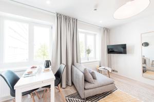 a white living room with a table and chairs at Forenom Serviced Apartments Helsinki Lauttasaari in Helsinki
