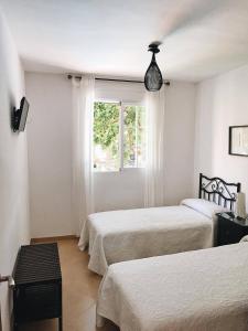a bedroom with two beds and a window at Casa rural Vía del Tranvía in La Zubia