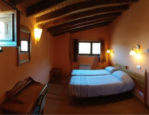 um quarto com uma cama, uma secretária e janelas em Veniata em San Pedro de las Herrerías
