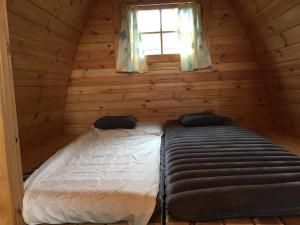 1 dormitorio con 2 camas en una cabaña de madera en Camping Le pommier rustique, en Yvoir