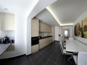 a kitchen with white cabinets and a table and chairs at Apartment OneClickRent 2 SmartHouse in Chişinău