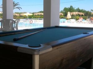 a pool table in front of a swimming pool at Nikos 2 Studios & Apartments in Kardamaina