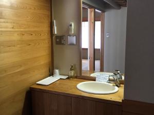 uma casa de banho com um lavatório e um espelho em Ryujin Onsen Marui Ryokan em Tanabe