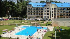 a resort with a pool and a large building at Apartament Rodzinny Blue Mare in Łukęcin