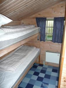 Tempat tidur dalam kamar di Lønstrup Camping Cottages & Rooms