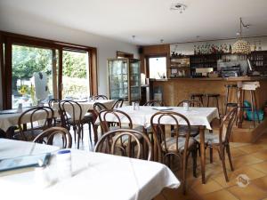 een eetkamer met witte tafels en stoelen bij Café Perlmuschel in Iznang