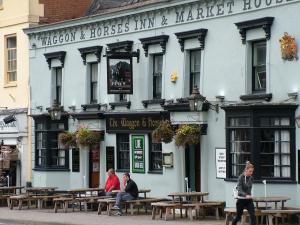 two people sitting at tables in front of a building at Stratford Apartment in Newmarket