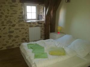 1 dormitorio con 1 cama con toallas en Le Relais d'Anglards, en Anglards-de-Saint-Flour