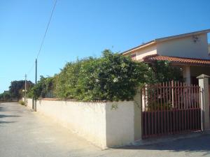 a fence in front of a house with a tree at casa del sole in Sciacca