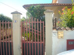 a red fence with a gate in front of a house at casa del sole in Sciacca