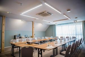 a conference room with long tables and chairs at Bulwary Biznes in Mielec