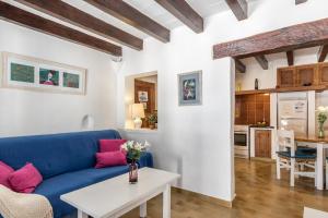 sala de estar con sofá azul y mesa en Blue fisherman house 2 By homevillas360, en Cala de Sant Vicent
