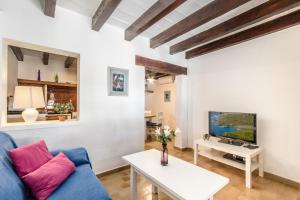 a living room with a blue couch and a tv at Blue fisherman house 2 By homevillas360 in Cala de Sant Vicent