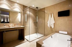 
a bathroom with a tub, toilet, sink and shower at Hotel Thermen Dilbeek in Dilbeek
