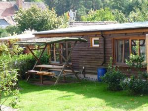 a small cabin with a porch and a swing at Haus Alwine in Borkheide +6 photos