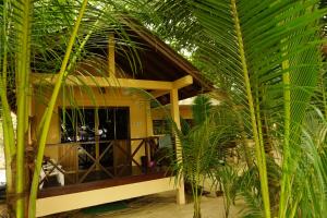 ein Haus mit Palmen davor in der Unterkunft Moonhut Bungalows in Mae Nam
