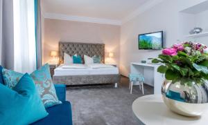 a hotel room with a bed and a vase of flowers at Villa Christina in Pörtschach am Wörthersee