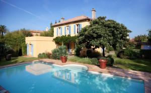 a large swimming pool in front of a house at Villa Les Glycines in Saint-Tropez